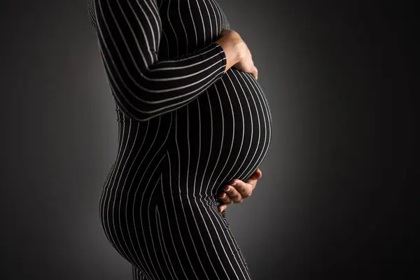 Primer Plano Una Mujer Embarazada Con Vestido Rayas Sosteniendo Suavemente Imagen de archivo