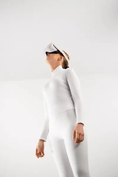 Женщина Белом Купальнике Взаимодействует Виртуальной Реальностью Стоя Минималистском Белом Пространстве Лицензионные Стоковые Фото