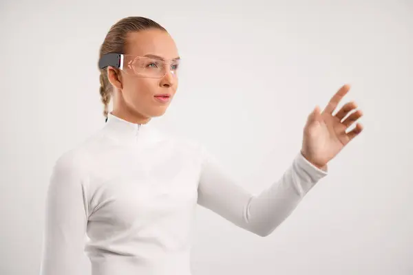Eine Junge Frau Interagiert Mit Futuristischer Tragbarer Technologie Trägt Schutzbrille Stockfoto