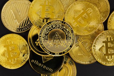 Cardano madeni parasının siyah arkaplan üzerindeki çeşitli altın kripto para birimlerinin genel görünümü