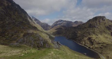 Yükselen dağlar, yemyeşil çimenler ve bulutlu bir gökyüzünün altında huzur ve el değmemiş vahşi doğanın cazibesini çağrıştıran huzurlu bir vadinin huzurlu manzarası..