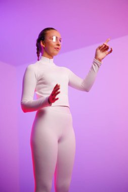 Akıllı gözlük takan ve mor arka planda hareket eden genç bir kadın.