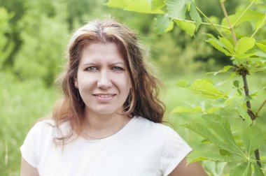 Orta yaşlı güzel bir kadın baharda parkta dinleniyor, çok mutlu çünkü yakında saçını beyaza boyamak için kuaföre gidecek.