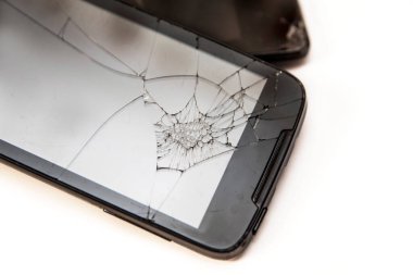 Kırık camlı, beyaz arka planda modern bir telefon. Telefon ergenin elinden düştü ve kaza yaptı. Yatay