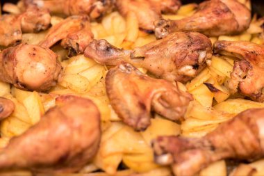 Kızarmış tavuk kanatları ve patatesli bacaklar evde iyi bir ev hanımıyla pişirilir.