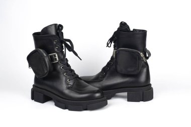 Kızlar için kış ya da sonbahar botları, beyaz arka planda küçük çantalar, sık sık yürümek için koyu çizmeler, su geçirmez. Kapat.