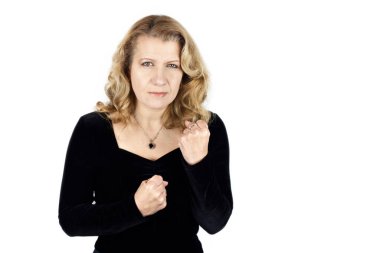 Üzgün yüzlü bir kadın partiden döndü ve yumruklarını önünde tutuyor. Kendini aile içi şiddetten korumaya hazır. Kadınların korunması, şiddet karşıtlığı