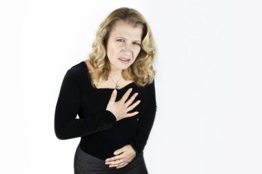 Siyah bluz ve etek giyen güzel olgun bir kadın göğsünü ve karnını tutuyor. Göğsünde ve karnında şiddetli bir ağrı var. Doktora görünmesi gerekiyor.