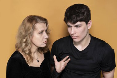 Ciddi bir yüzü olan bir kadın genç oğlunu eleştirir, çocuk mütevazi bir şekilde annesini sabırla dinler. Genç bir çocuk ve annesinin portresi, iletişim kuruyorlar. Yetiştirilme kavramı