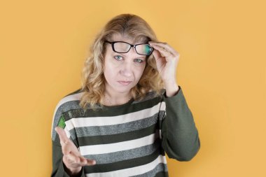 Katı bakışları olan olgun bir kadın birine ne yapması gerektiğini soruyor gibi görünüyor. Kadın müşteri olarak hizmetlerinden memnun değil, öfkeli. Kızgın yüzlü gözlüklü bir kadın.