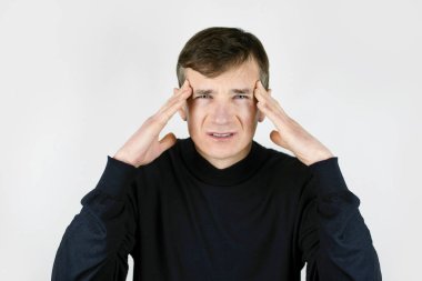 Olgun bir adam kafasını tutuyor, iş stresinden sonra şiddetli bir baş ağrısı çekiyor, hafif arka planda acı çeken bir adam. Stres konsepti, erkeklerde baş ağrısı