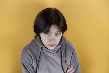 Sarı arka planda, üzgün yüzlü bir kız, ailesi ve arkadaşlarıyla depresyon ve yanlış anlaşılmalar yaşıyor, kızın gençlik sorunları var, üst düzey bir bakış açısı var.