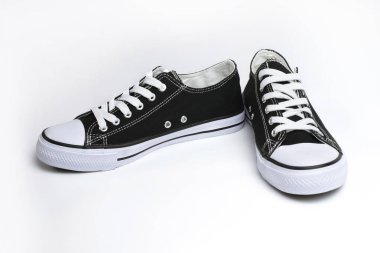 Hafif arka planda siyah-beyaz spor ayakkabılar, yaz koşuları için klasik hafif spor ayakkabılar, açık hava eğlencesi, düz taban, havalandırma delikli kumaş üst, kapatın.