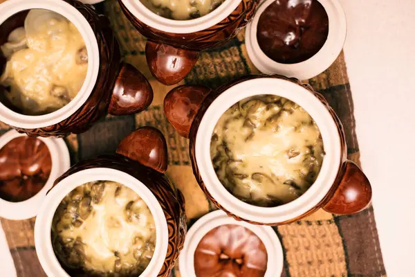 İçinde yiyecek olan kil çömlek. Mantarlı patates, sebze ve peynir. Lezzetli ve sağlıklı yiyecekler. Üst görünüm