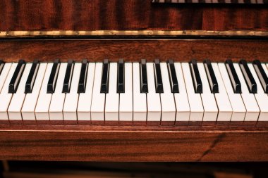 Siyah ve beyaz tuşlu eski kahverengi bir piyano. Üst Manzara. Yatay