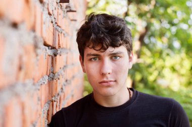 Parkta ihtiyatlı üzgün bakan yakışıklı bir adamın portresi. Üniversitede arkadaşlarıyla kavga etmiş ve doğada sakinleşmek için yürüyüşe çıkmış.