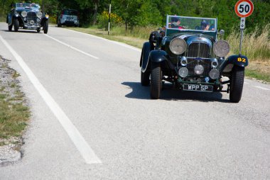 URBINO, İtalya - 16 Haziran 2022 LADA M45 RAPIDE 1934 Mille Miglia 2022 rallisinde eski bir yarış arabası üzerinde ünlü İtalyan tarihi yarışı