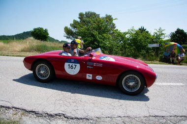 URBINO, İtalya - 16 HAZİRAN - 2022 O.S.C.A. MT4 1100 1949 rallisinde eski bir yarış arabasında Mille Miglia 2022 ünlü İtalyan tarihi yarışı