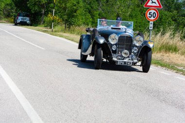 URBINO, İtalya - 16 Haziran 2022 LADA M45 RAPIDE 1934 Mille Miglia 2022 rallisinde eski bir yarış arabası üzerinde ünlü İtalyan tarihi yarışı