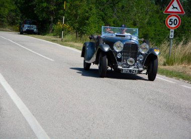 URBINO, İtalya - 16 Haziran 2022 LADA M45 RAPIDE 1934 Mille Miglia 2022 rallisinde eski bir yarış arabası üzerinde ünlü İtalyan tarihi yarışı