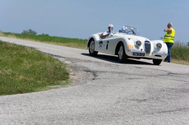 URBINO, ITALY - JUN 16 - 2022 : JAGUAR XK120 OTS ROADSTER 1954 on an old racing car in rally Mille Miglia 2022 the famous italian historical race