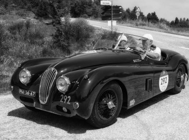 URBINO, ITALY - JUN 16 - 2022 : JAGUAR XK140 OTS ROADSTER 1956 on an old racing car in rally Mille Miglia 2022 the famous italian historical race