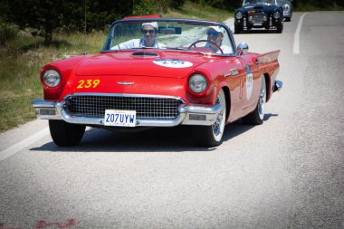 URBINO, ITALY - JUN 16 - 2022 : FORD THUNDERBIRD 1957 on an old racing car in rally Mille Miglia 2022 the famous italian historical race