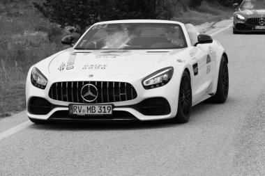 URBINO - ITALY - JUN 16 - 2022 : Mercedes AMG GT Cabrio on an old racing car in rally Mille Miglia 2022 the famous italian historical race