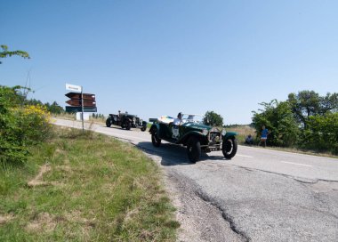 URBINO, İtalya - 16 Haziran 2022: LANCIA LAMBDA TIPO 221 VIII SERIE 1928 Mille Miglia 2022 rallisinde eski bir yarış arabası üzerinde ünlü İtalyan tarihi yarış yarışı