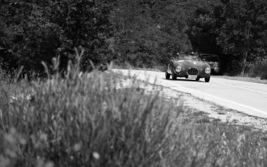 URBINO, İtalya - 16 HAZİRAN - 2022 O.S.C.A. MT4 1100 1949 rallisinde eski bir yarış arabasında Mille Miglia 2022 ünlü İtalyan tarihi yarışı