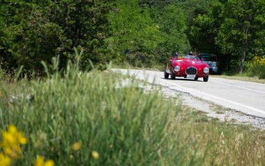 URBINO, İtalya - 16 HAZİRAN - 2022 O.S.C.A. MT4 1100 1949 rallisinde eski bir yarış arabasında Mille Miglia 2022 ünlü İtalyan tarihi yarışı