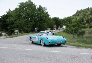 URBINO, İtalya - 16 Haziran 2022: CHEVROlet CORVETTE 1957 Mille Miglia 2022 rallisinde eski bir yarış arabası üzerinde ünlü İtalyan tarihi yarışı