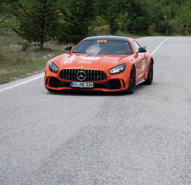 URBINO - ITALY - JUN 16 - 2022 : Mercedes AMG GT Coupe on an old racing car in rally Mille Miglia 2022 the famous italian historical race