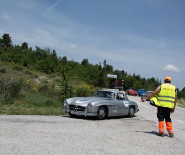 URBINO, İtalya - 16 Haziran 2022: MERCEDES BENZ 300 SL W198 1955 Mille Miglia 2022 rallisinde eski bir yarış arabası üzerinde ünlü İtalyan tarihi yarış yarışı