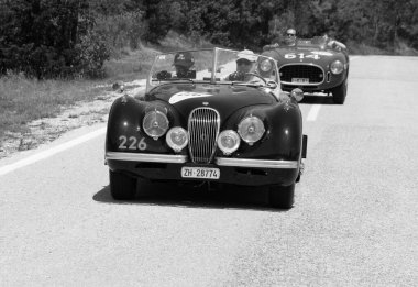 URBINO, İtalya - 16 Haziran 2022: JAGUAR XK120 OTS YOADSTER 1952 Mille Miglia 2022 rallisinde eski bir yarış arabası üzerinde ünlü İtalyan tarihi yarışı