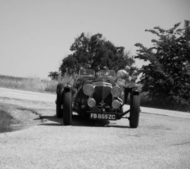 URBINO, İtalya - 16 Haziran 2022: ASTON MARTIN LE MANS 1933 Mille Miglia 2022 rallisindeki eski bir yarış arabasında ünlü İtalyan tarihi yarışı