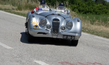URBINO, İtalya - 16 Haziran 2022: JAGUAR XK120 OTS YOADSTER 1953 Mille Miglia 2022 rallisinde eski bir yarış arabası üzerinde ünlü İtalyan tarihi yarışı