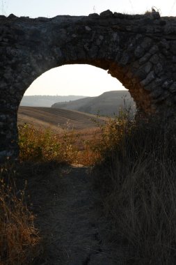 Nefes kesen bir günbatımı, Monte Romano 'daki antik Roma su kemeri kalıntılarının üzerine sıcak, altın rengi döküyor. Yıpranmış taş kemerler dimdik, renkli gökyüzüne karşı siluet, tarih ve ebedi güzelliği çağrıştırıyor..