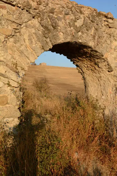 Nefes kesen bir günbatımı, Monte Romano 'daki antik Roma su kemeri kalıntılarının üzerine sıcak, altın rengi döküyor. Yıpranmış taş kemerler dimdik, renkli gökyüzüne karşı siluet, tarih ve ebedi güzelliği çağrıştırıyor..