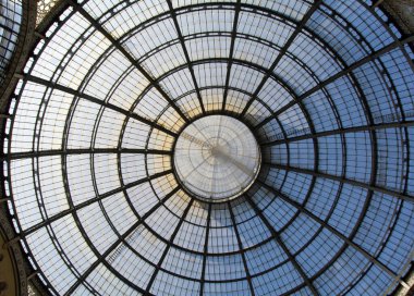 Milano 'daki Galleria Vittorio Emanuele II kubbesine yakın çekim. Karmaşık cam ve demir tasarımını aydınlatan güneş ışığı dekoratif detayları aydınlatıyor..