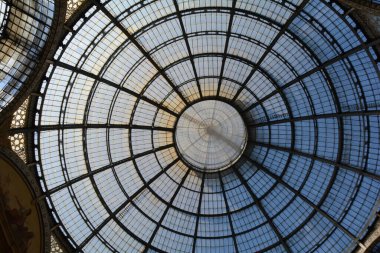 Milano 'daki Galleria Vittorio Emanuele II kubbesine yakın çekim. Karmaşık cam ve demir tasarımını aydınlatan güneş ışığı dekoratif detayları aydınlatıyor..