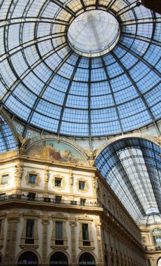 Milano 'daki Galleria Vittorio Emanuele II kubbesine yakın çekim. Karmaşık cam ve demir tasarımını aydınlatan güneş ışığı dekoratif detayları aydınlatıyor..