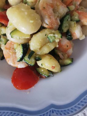 Yumuşak karides, doğranmış kabak ve vişneli domatesle servis edilen lezzetli bir tabak kremalı gnocchi. Bu canlı deniz ürünleri makarnası rahatlatıcı ama zarif bir yemek için mükemmel.. 