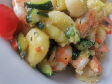 Yumuşak karides, doğranmış kabak ve vişneli domatesle servis edilen lezzetli bir tabak kremalı gnocchi. Bu canlı deniz ürünleri makarnası rahatlatıcı ama zarif bir yemek için mükemmel.. 