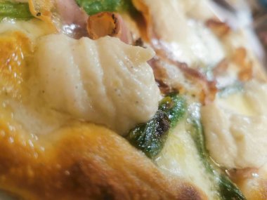 İçinde kremalı ricotta kıvrımları, çıtır domuz pastırması, taze kuşkonmaz ve kahverengi kabuklu erimiş peynir olan lezzetli bir zanaatkar pizza. Mükemmel pişmiş ve lezzetten patlıyor..
