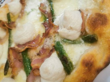 İçinde kremalı ricotta kıvrımları, çıtır domuz pastırması, taze kuşkonmaz ve kahverengi kabuklu erimiş peynir olan lezzetli bir zanaatkar pizza. Mükemmel pişmiş ve lezzetten patlıyor..