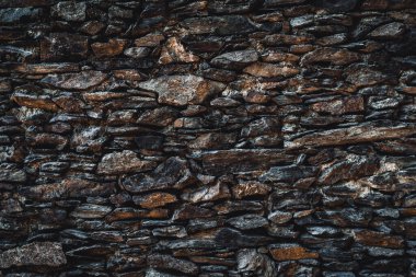 Taş duvar dokusu. Yığılmış taşlar yüzeye çıkıyor. Gri renkli soyut doğal arkaplan.