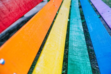 LGBTIQ + konsepti. Tüm kollektifleri temsil etmek için gökkuşağı renkleriyle boyanmış çok renkli park bankı. LGBT Gurur ve Eşcinsel Gururu Günü. Tüm arkaplan için eşitlik ve saygı.