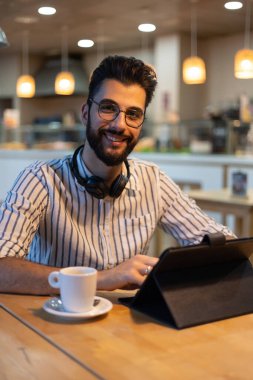 Fırının içinde gülümseyen sakallı yakışıklı bir adamın portresi.