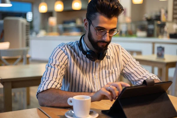 stock image Handsome man with beard looking at tablet inside a bakery